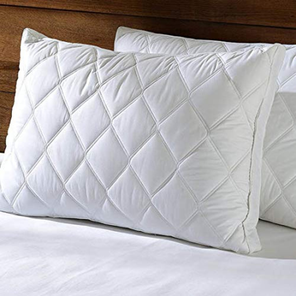 a white bed with white sheets and pillows 